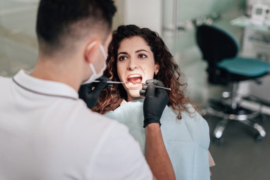 a girl is showing her teeth to dentist